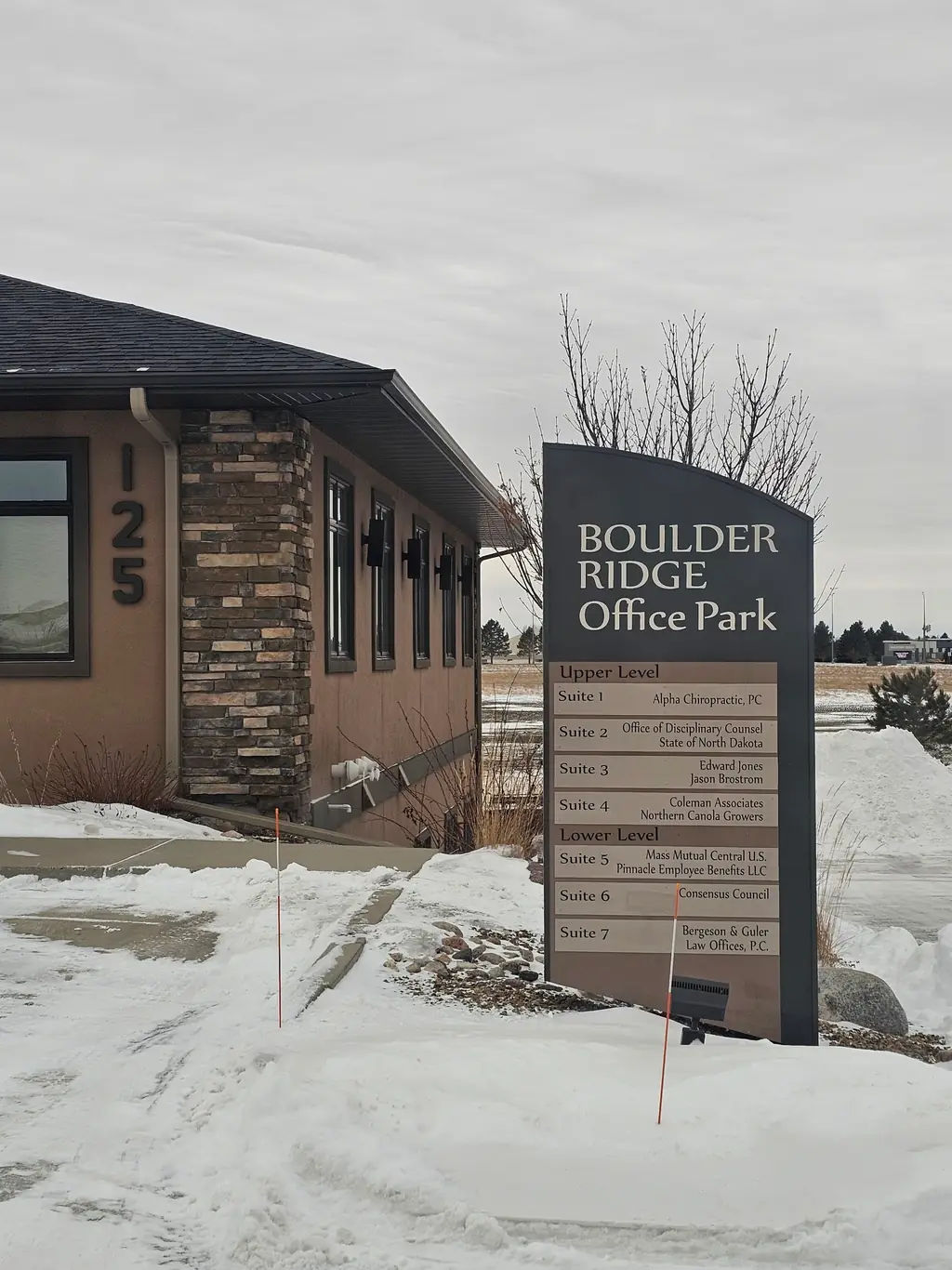 Winter exterior of the Boulder Ridge Office Park building with the directory sign listing Alpha Chiropractic, PC